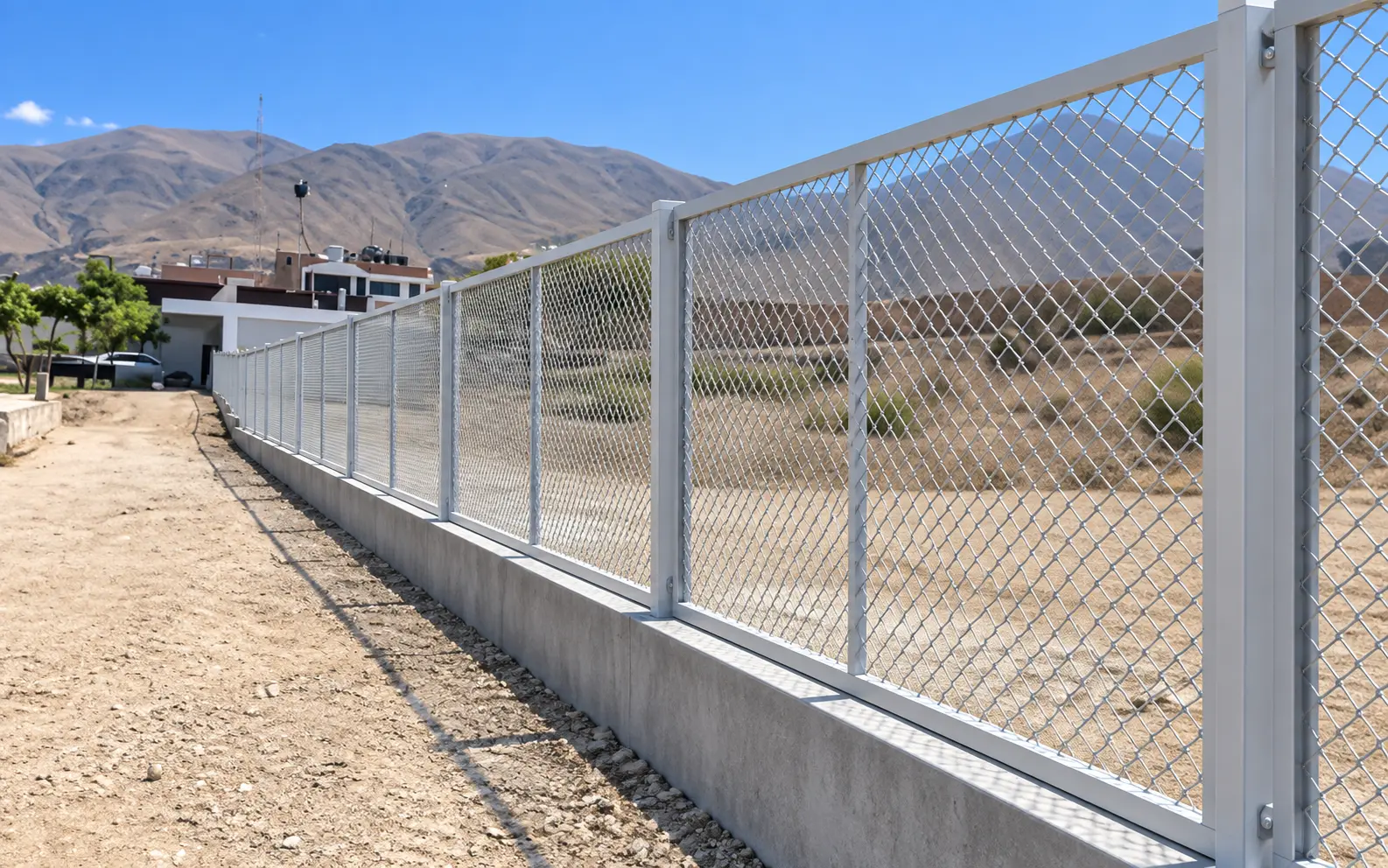Cerco industrial de malla olímpica galvanizada sobre sobrecimiento de concreto, perímetro de planta en Arequipa