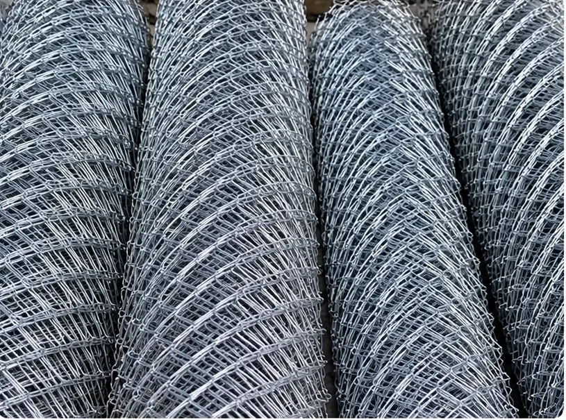 Rollos de malla galvanizada apilados, tejido romboidal visible