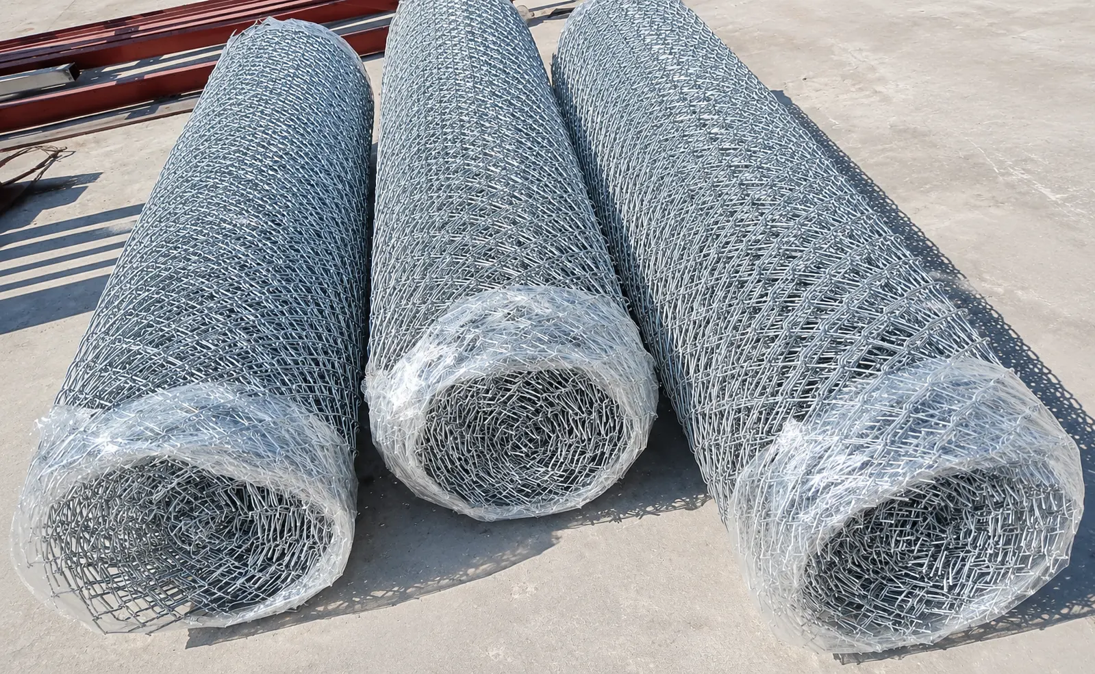 Rollos de malla olímpica galvanizada con extremos torcidos, embalados y listos para despacho en Arequipa